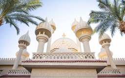 Traditional Islamic mosque under palm trees in sunny weather (Image by pvproductions on Freepik)